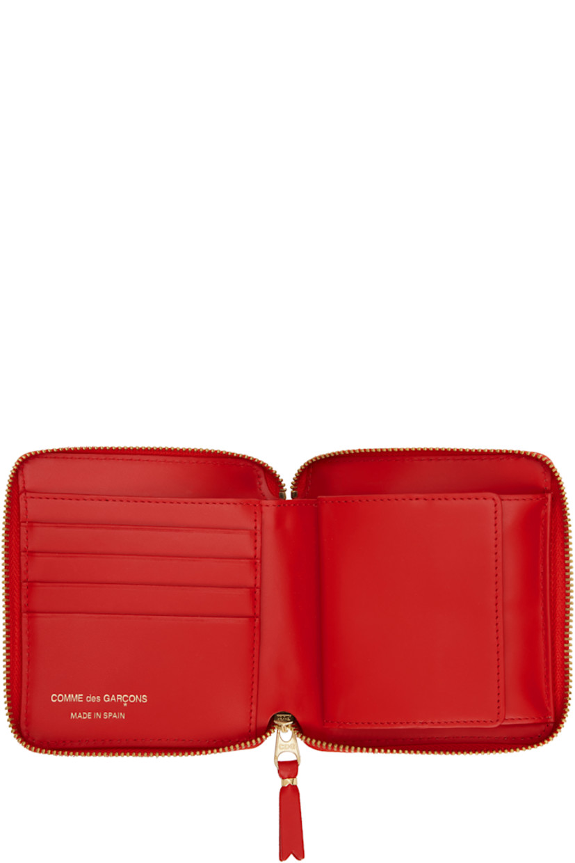 Buffed leather wallet in red.

· Bow accent at face
· Zip closure
· Four card slots at interior
· One patch pocket
· One note slot
· Press-stud coin compartment
· Grained leather lining
· H4.75" x W4.25" x D1"

Supplier color: Red