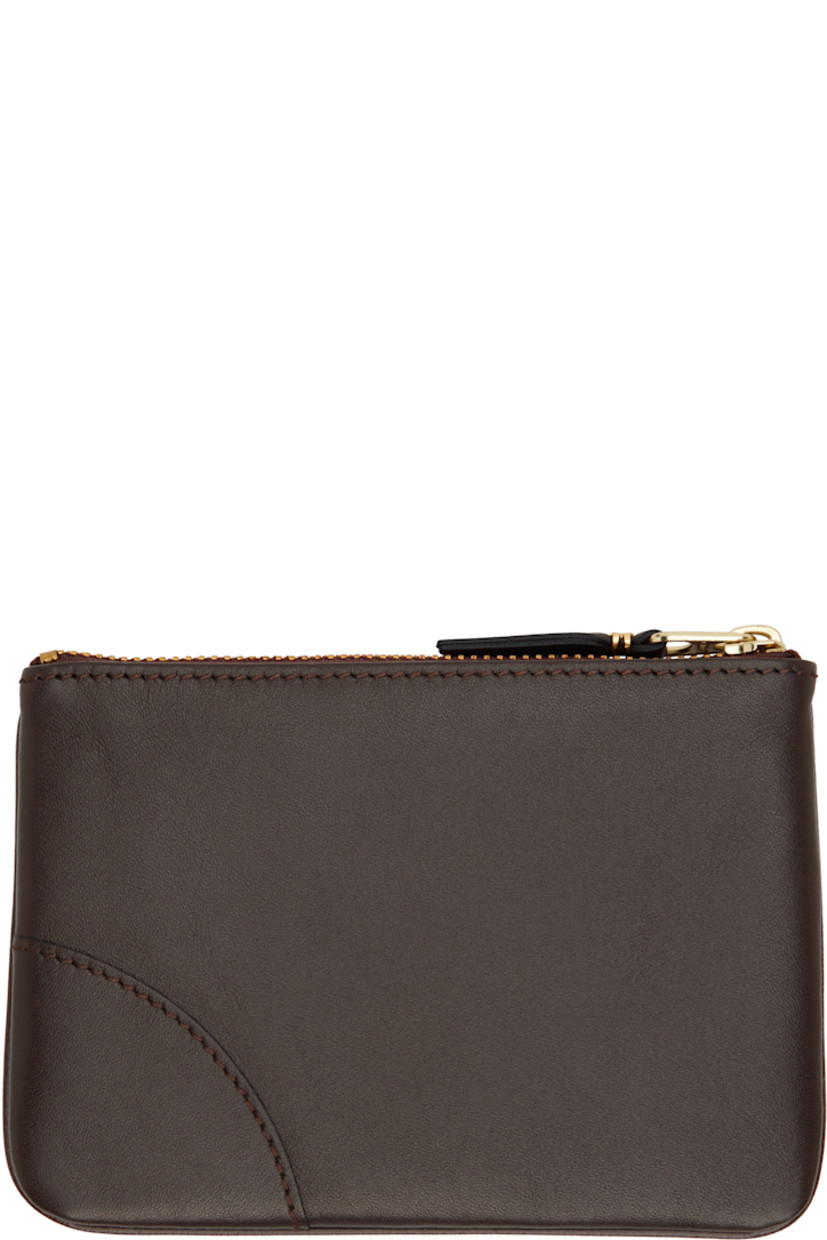 Buffed leather pouch in brown.

· Logo stamp at face
· Seam at face and back face
· Zip closure
· Suede interior
· Logo-engraved gold-tone hardware
· H4" x W5.5"

Supplier color: Brown