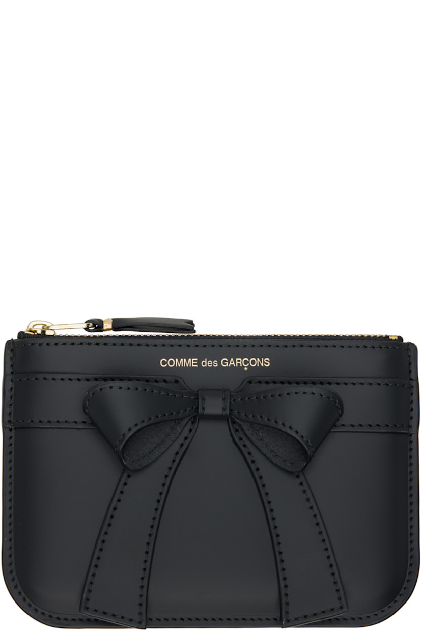 Buffed leather wallet.

· Bow accent and logo stamp at face
· Zip closure
�· Grained leather lining 
· H4" x W6"

Supplier color: Black