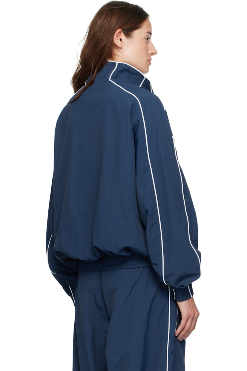 Nylon taffeta track jacket.

· Piping throughout
· Stand collar
· Zip closure
· Logos embroidered at chest
· Zip pockets at waist
· Elasticized hem and cuffs
· Dropped shoulders
· Welt pocket at interior
· Full mesh lining
· Logo-engraved antiqued gold-tone hardware

Supplier color: Prussian blue