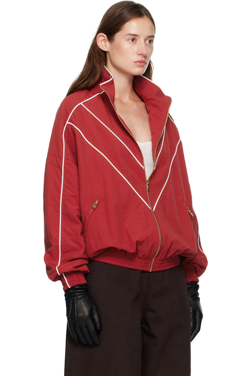 Nylon taffeta track jacket.

· Piping throughout
· Stand collar
· Zip closure
· Logos embroidered at chest
· Zip pockets at waist
· Elasticized hem and cuffs
· Dropped shoulders
· Welt pocket at interior
· Full mesh lining
· Logo-engraved antiqued gold-tone hardware

Supplier color: Red