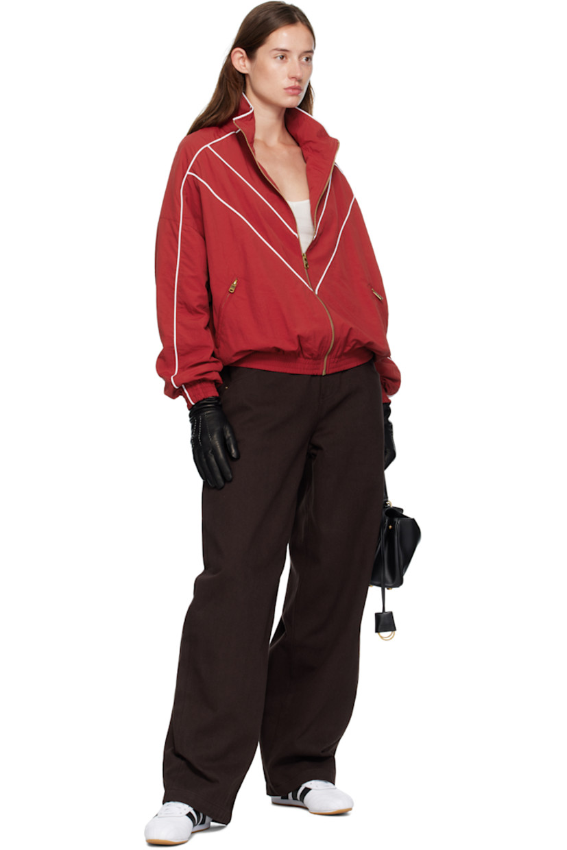 Nylon taffeta track jacket.

· Piping throughout
· Stand collar
· Zip closure
· Logos embroidered at chest
· Zip pockets at waist
· Elasticized hem and cuffs
· Dropped shoulders
· Welt pocket at interior
· Full mesh lining
· Logo-engraved antiqued gold-tone hardware

Supplier color: Red