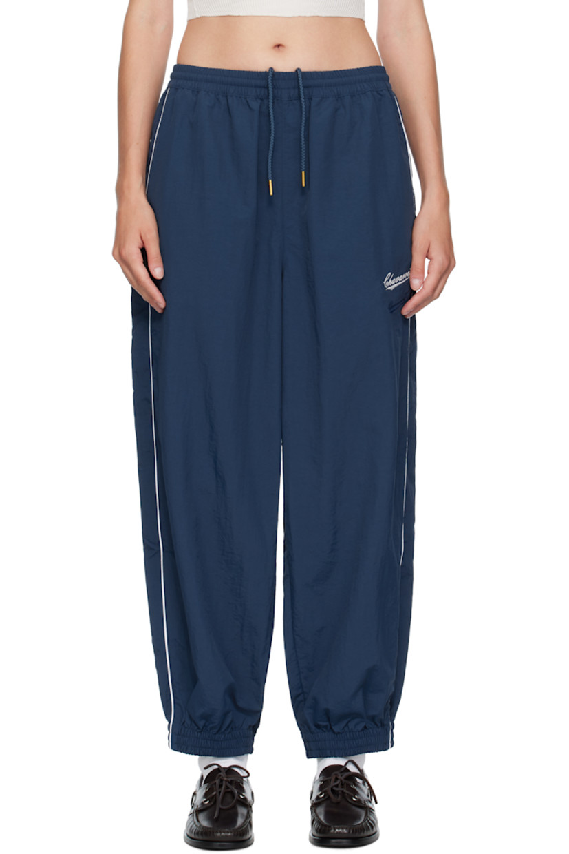Lightweight nylon taffeta track pants.

· Loose-fit
· Concealed drawstring at elasticized waistband
· Two-pocket styling
· Logos embroidered at front
· Elasticized cuffs
· Piping at outseams
· Dropped inseam

Supplier color: Prussian blue