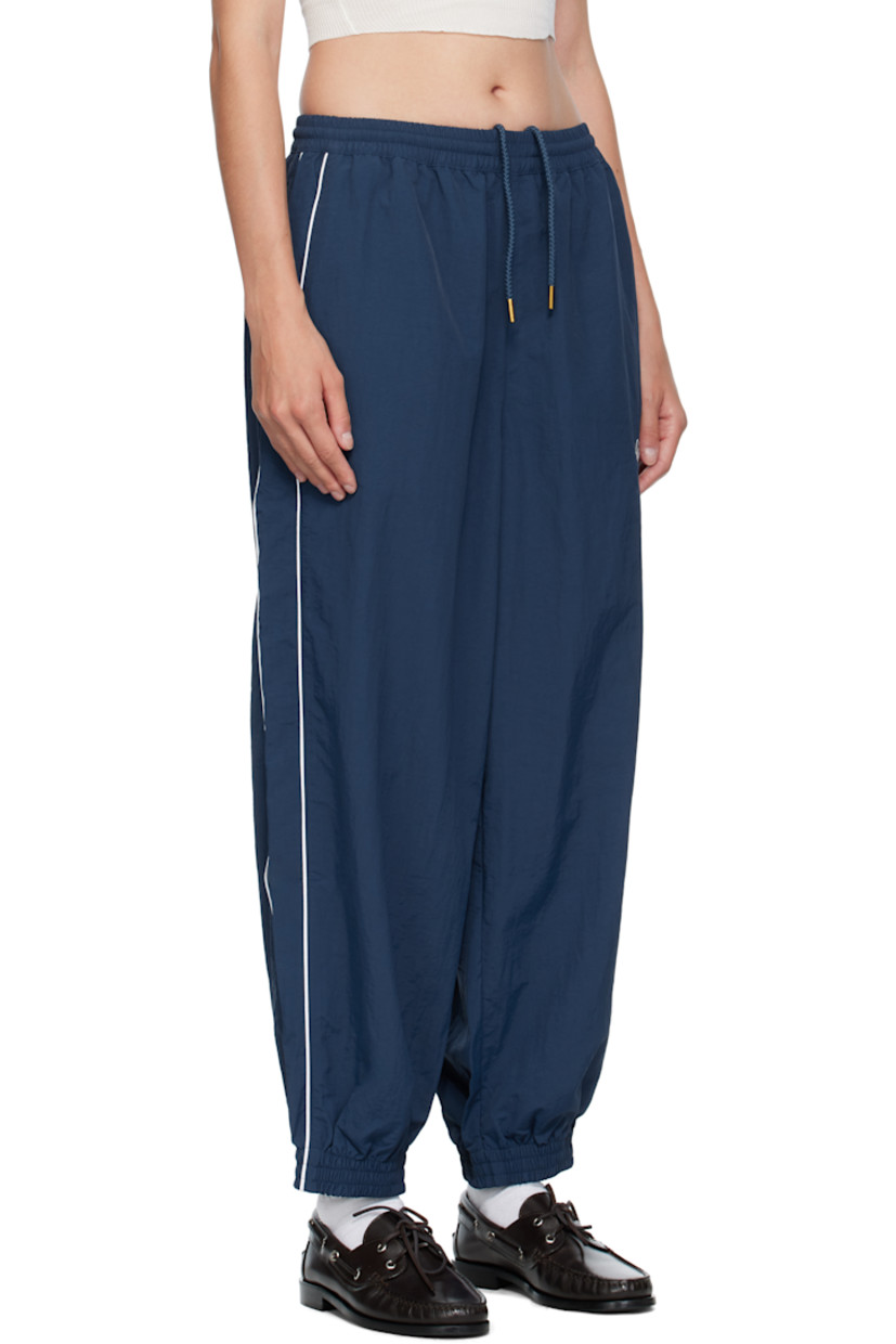 Lightweight nylon taffeta track pants.

· Loose-fit
· Concealed drawstring at elasticized waistband
· Two-pocket styling
· Logos embroidered at front
· Elasticized cuffs
· Piping at outseams
· Dropped inseam

Supplier color: Prussian blue