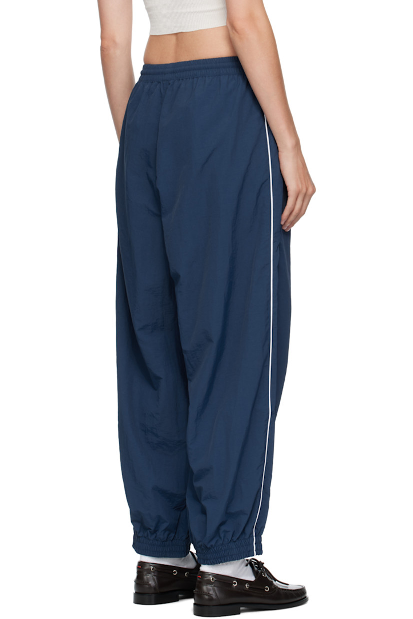 Lightweight nylon taffeta track pants.

· Loose-fit
· Concealed drawstring at elasticized waistband
· Two-pocket styling
· Logos embroidered at front
· Elasticized cuffs
· Piping at outseams
· Dropped inseam

Supplier color: Prussian blue