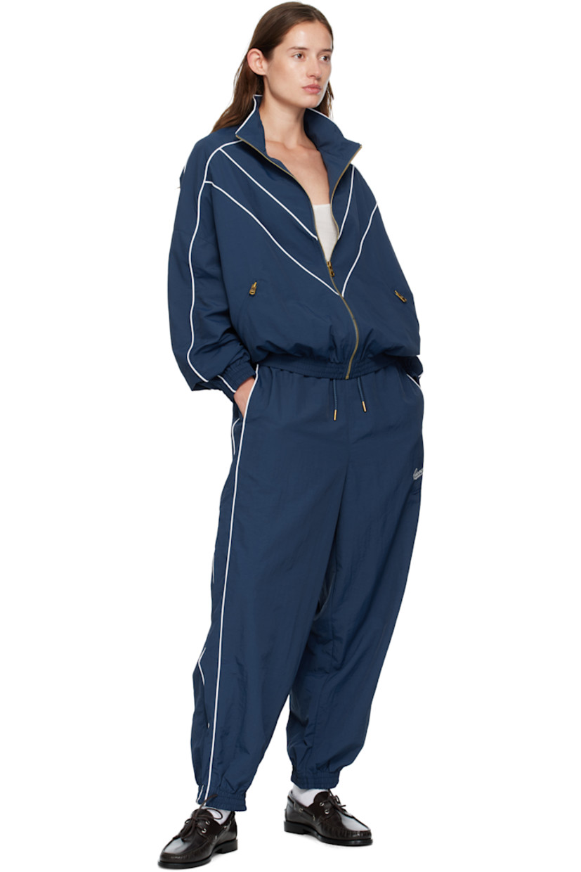 Lightweight nylon taffeta track pants.

· Loose-fit
· Concealed drawstring at elasticized waistband
· Two-pocket styling
· Logos embroidered at front
· Elasticized cuffs
· Piping at outseams
· Dropped inseam

Supplier color: Prussian blue