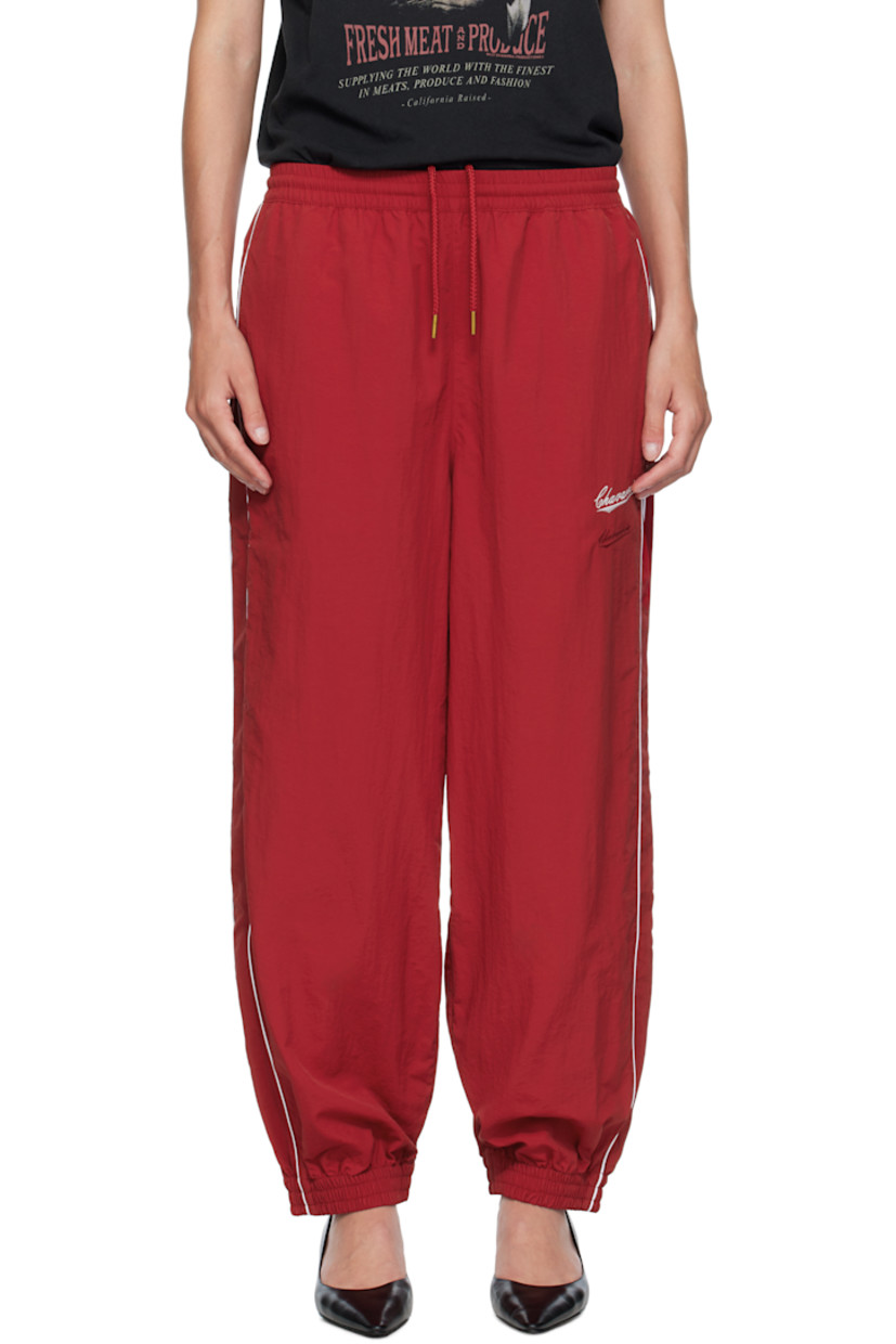 Lightweight nylon taffeta track pants.

· Loose-fit
· Concealed drawstring at elasticized waistband
· Two-pocket styling
· Logos embroidered at front
· Elasticized cuffs
· Piping at outseams
· Dropped inseam

Supplier color: Red