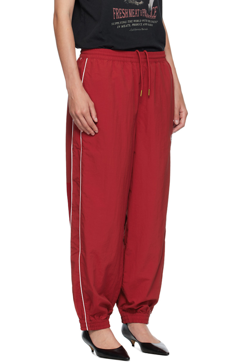 Lightweight nylon taffeta track pants.

· Loose-fit
· Concealed drawstring at elasticized waistband
· Two-pocket styling
· Logos embroidered at front
· Elasticized cuffs
· Piping at outseams
· Dropped inseam

Supplier color: Red