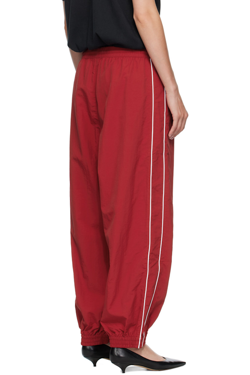 Lightweight nylon taffeta track pants.

· Loose-fit
· Concealed drawstring at elasticized waistband
· Two-pocket styling
· Logos embroidered at front
· Elasticized cuffs
· Piping at outseams
· Dropped inseam

Supplier color: Red