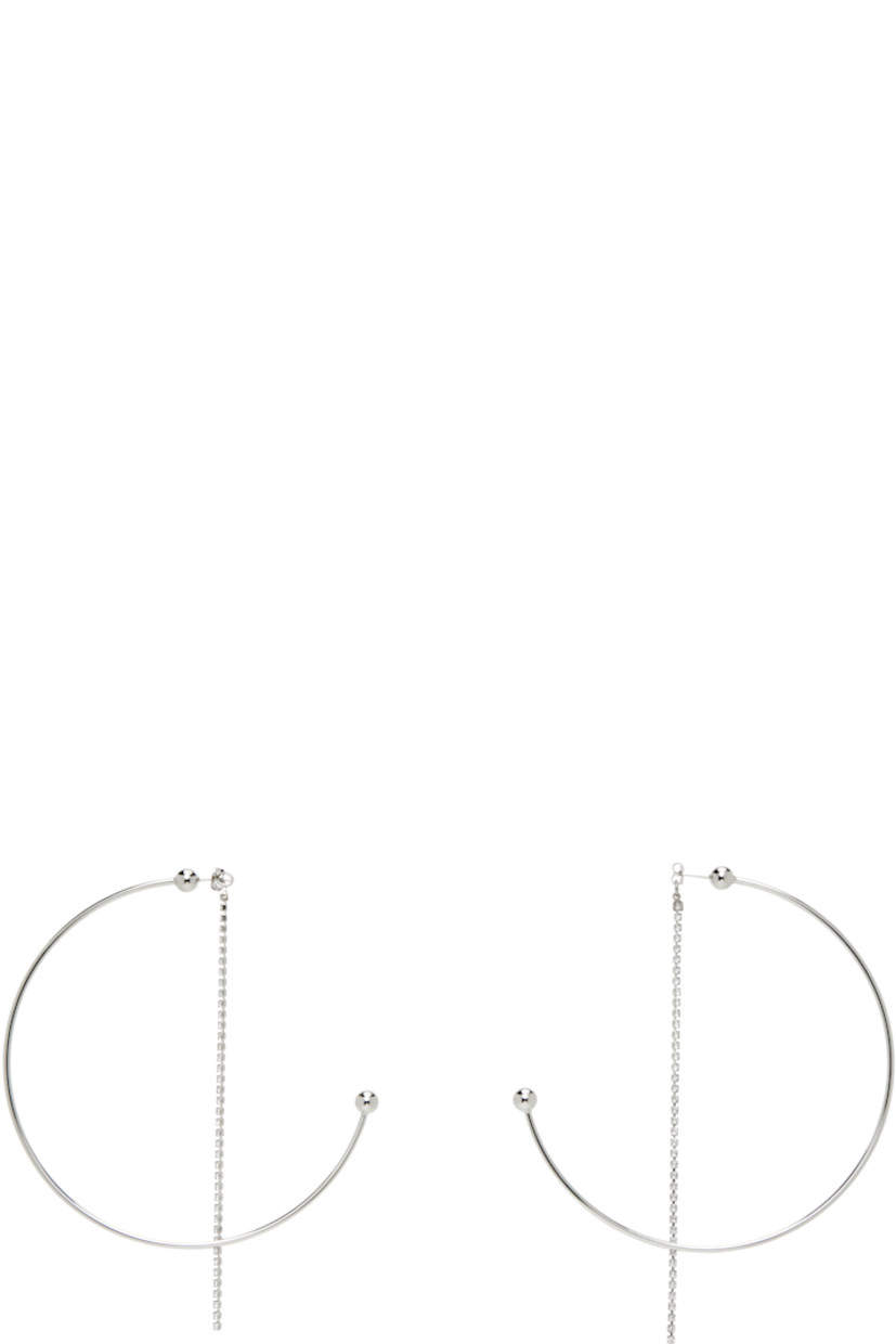 Pair of handcrafted open hoop earrings in palladium-plated brass.

· Cup chain with crystals at fastening 
· Post-stud fastening 
· D4"

Supplier color: Palladium