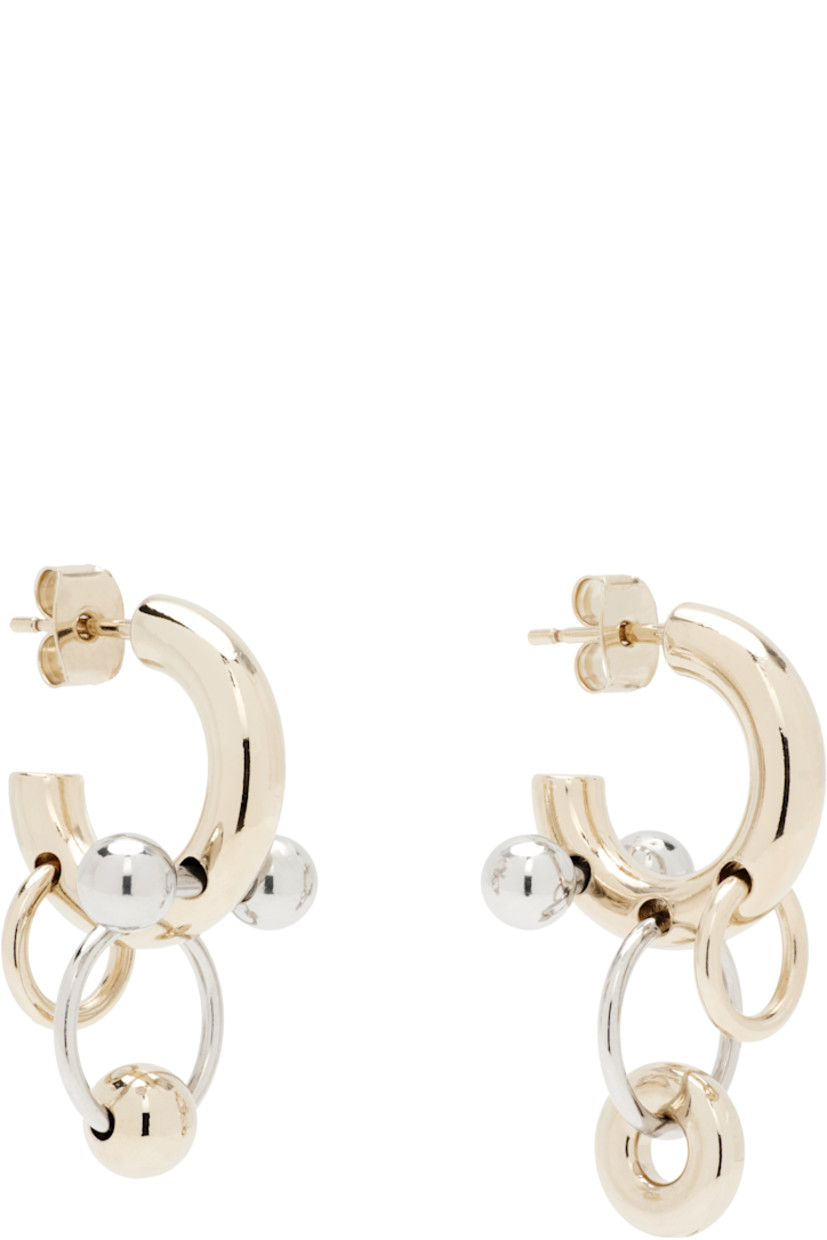 Pair of handcrafted open hoop earrings in 24k gold- and palladium-plated brass.

· Mismatched charms at drop 
· Post-stud fastening 
· D0.5"

Supplier color: Palladium