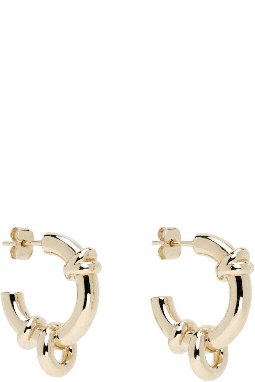 Pair of handcrafted open hoop earrings in 24k gold-plated brass.

· O-rings at hoop
· Post-stud fastening 
· D1"

Supplier color: Gold