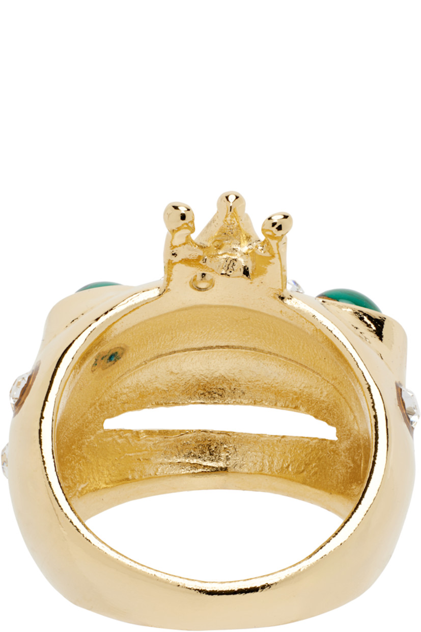 Hand-enameled recycled pewter ring in gold tone.

· Graphic hardware at top
· Cabochon and slit at face
· Deadstock crystals 

Supplier color: Emerald gold freckles