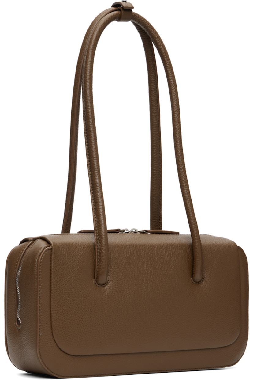 Pebble-grained calfskin shoulder bag.

· Post-stud tab at fixed shoulder straps
· Logo embossed at face
· Two-way zip closure
· Card slot at interior
· Faille lining
· H5" x W10.25" x D3"

Supplier color: Grain brownie