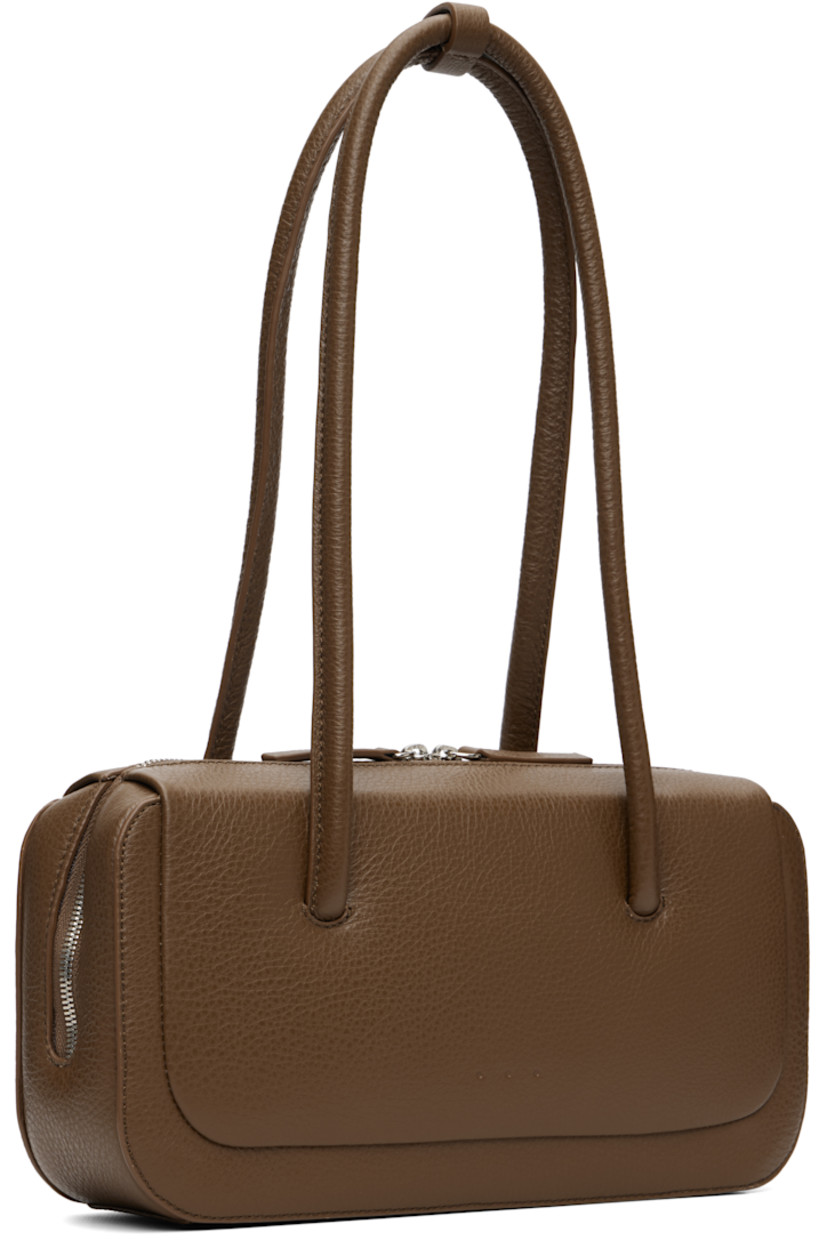 Pebble-grained calfskin shoulder bag.

· Post-stud tab at fixed shoulder straps
· Logo embossed at face
· Two-way zip closure
· Card slot at interior
· Faille lining
· H5" x W10.25" x D3"

Supplier color: Grain brownie