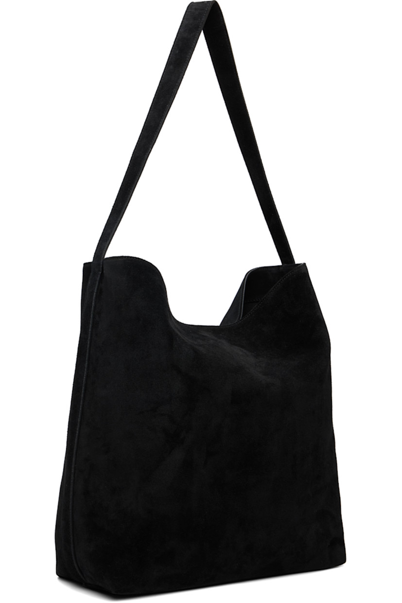 Calfskin suede tote.

· Fixed shoulder strap
· Logo embossed at face
· Magnetic fastening at open throat
· Patch pocket at interior
· Faille lining
· H13" x W16" x D5"

Supplier color: Suede black