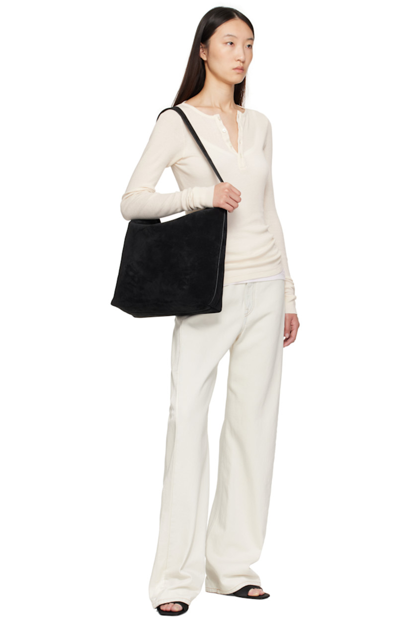 Calfskin suede tote.

· Fixed shoulder strap
· Logo embossed at face
· Magnetic fastening at open throat
· Patch pocket at interior
· Faille lining
· H13" x W16" x D5"

Supplier color: Suede black