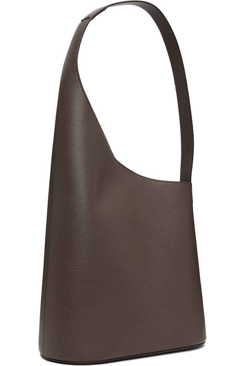 Pebble-grained calfskin tote.

· Fixed shoulder strap
· Logo embossed at face
· Magnetic closure
· Patch pocket at interior
· Unlined
· H17.5" x W11" x D5.5"

Supplier color: Grain chestnut