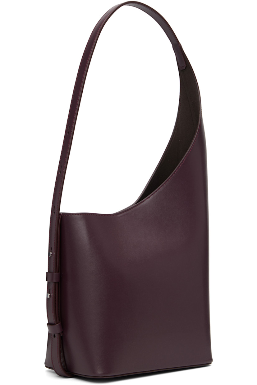 Buffed calfskin shoulder bag.

· Adjustable shoulder strap
· Logo embossed at face
· Magnetic closure
· Patch pocket at eco-suede interior
· H15.5" x W8" x D4.5"
· Total height: H18"

Supplier color: Fig