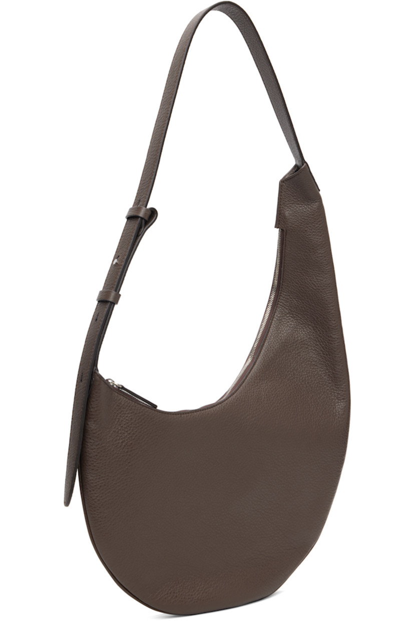 Pebble-grained calfskin shoulder bag.

· Fixed shoulder strap
· Logo embossed at face
· Zip closure
· Patch pocket at interior
· Faille lining
· H6" x W10.5" x D0.75"
· Total height: H17"

Supplier color: Grain chestnut