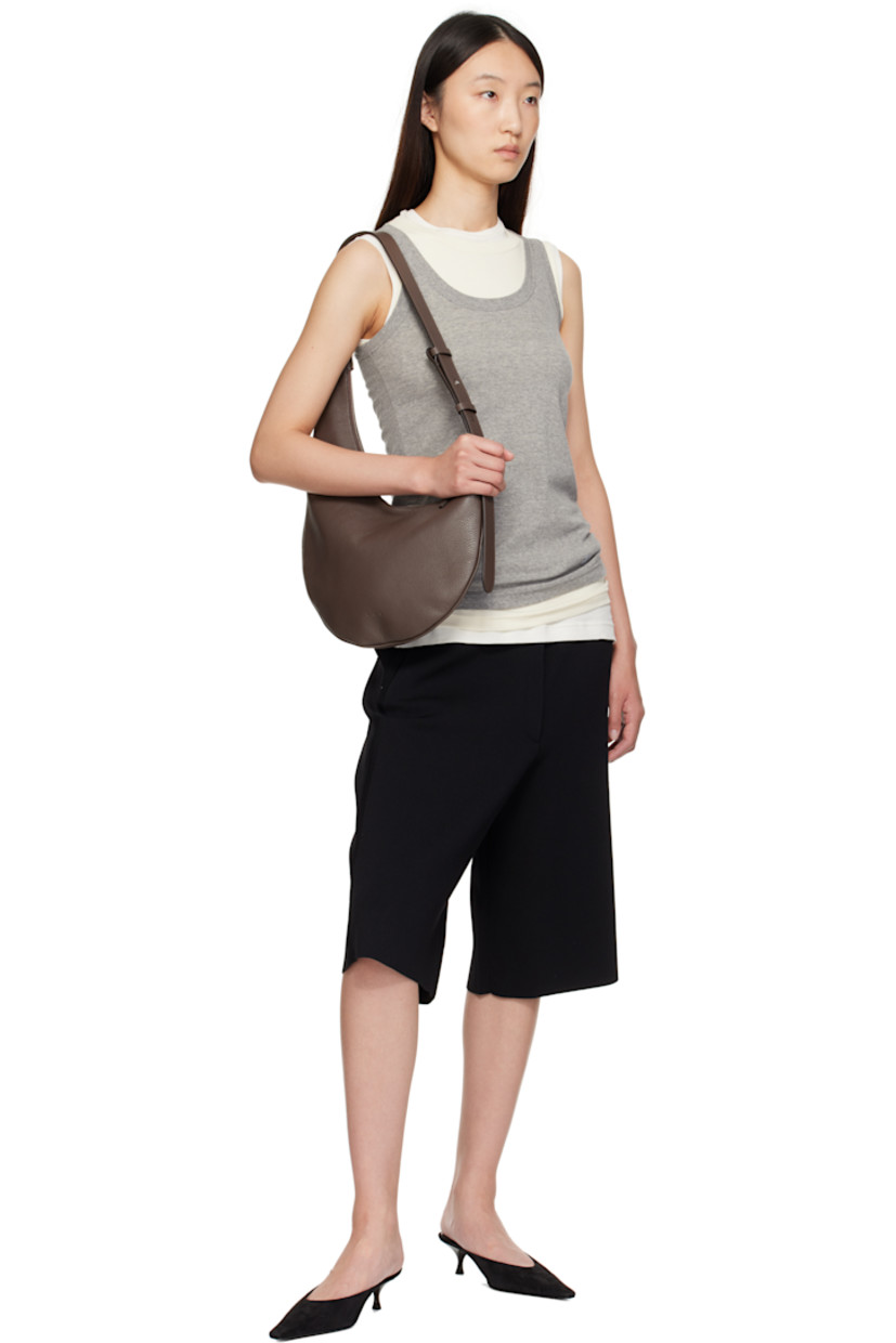 Pebble-grained calfskin shoulder bag.

· Fixed shoulder strap
· Logo embossed at face
· Zip closure
· Patch pocket at interior
· Faille lining
· H6" x W10.5" x D0.75"
· Total height: H17"

Supplier color: Grain chestnut