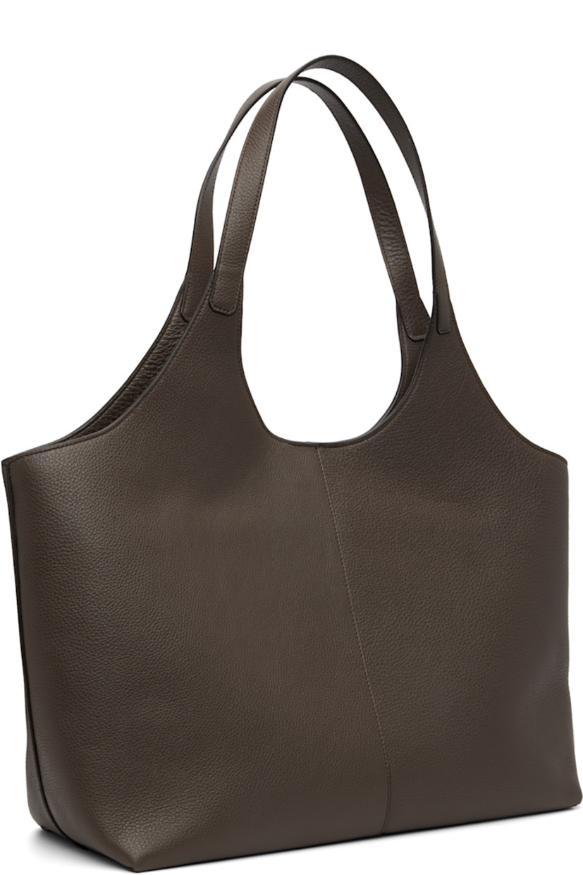 Pebble-grained calfskin tote.

· Fixed shoulder straps
· Logo embossed at face
· Magnetic closure
· Patch pocket at interior
· Faille lining
· H11.75" x W21" x D6"

Supplier color: Grain chestnut