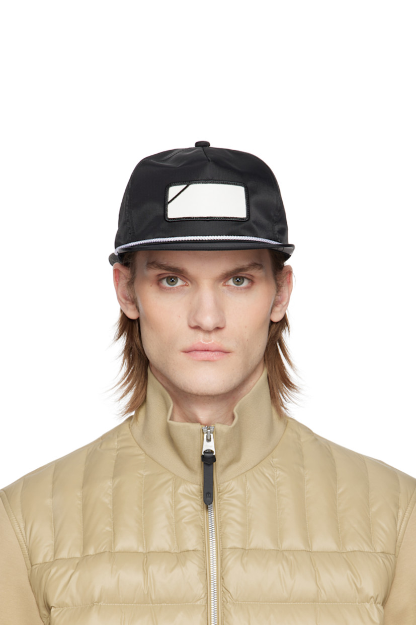 Nylon twill cap in black. 

· Graphic patch at face
· Braided piping at flat brim
· Logo embroidered at back face
· Faux-leather cinch fastening 
· Structured mesh panel at interior 
· Plain-woven browband
· Twill lining
· Logo-engraved black hardware

Supplier color: Black
