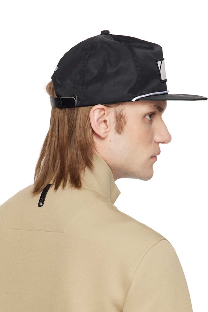 Nylon twill cap in black. 

· Graphic patch at face
· Braided piping at flat brim
· Logo embroidered at back face
· Faux-leather cinch fastening 
· Structured mesh panel at interior 
· Plain-woven browband
· Twill lining
· Logo-engraved black hardware

Supplier color: Black