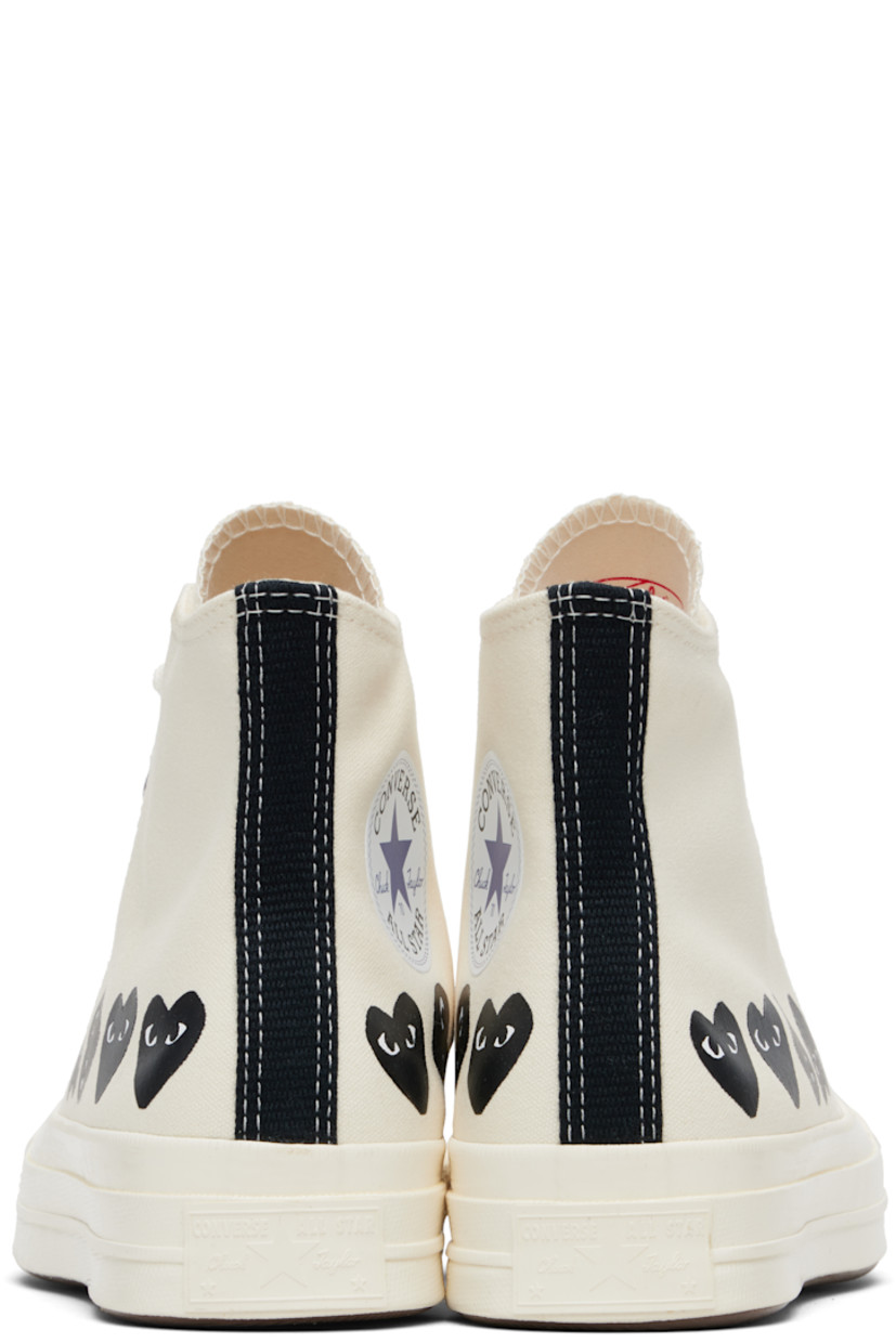 High-top canvas sneakers.

· Rubber cap toe
· Lace-up closure
· Logo printed at sides
· Eyelets and bonded logo at inner side
· Webbing trim and rubber logo patch at heel
· Cushioned Ortholite® footbed
· Treaded rubber sole

Part of the Comme des Garçons Play x Converse collaboration.

Supplier color: Beige