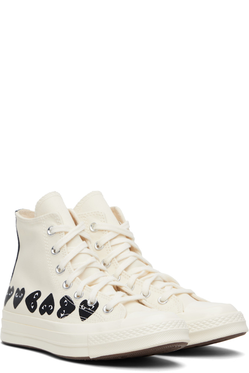 High-top canvas sneakers.

· Rubber cap toe
· Lace-up closure
· Logo printed at sides
· Eyelets and bonded logo at inner side
· Webbing trim and rubber logo patch at heel
· Cushioned Ortholite® footbed
· Treaded rubber sole

Part of the Comme des Garçons Play x Converse collaboration.

Supplier color: Beige
