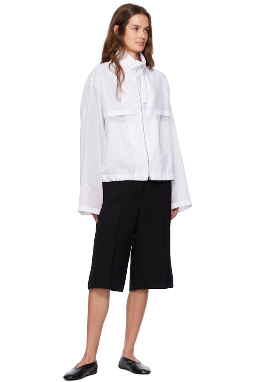Sheer cotton muslin jacket.

· Paneled construction
· Stand collar
· Two-way zip closure
· Storm flap at front and back
· Zip pockets at waist
· Drawstring at hem
· Unlined

Supplier color: White