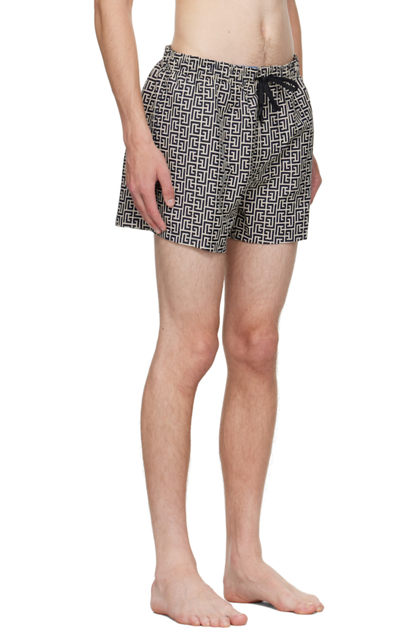 Stretch nylon twill swim shorts.

· Jacquard logo graphic pattern throughout 
· Drawstring at elasticized waistband 
· Three-pocket styling
· Grommets at back waist
· Mesh brief-style lining 

Supplier color: Ivory/Black