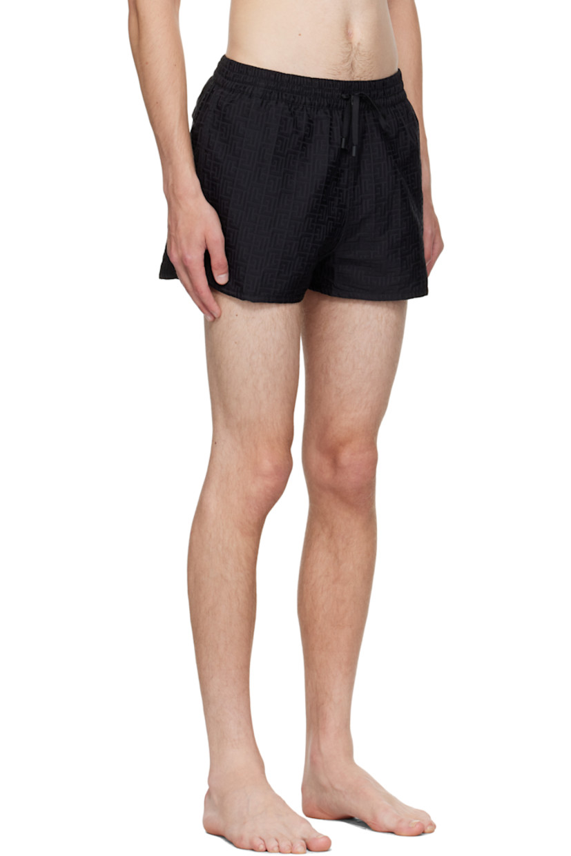 Twill swim shorts.

· Jacquard logo graphic pattern throughout 
· Drawstring at elasticized waistband 
· Three-pocket styling
· Grommets at back waist
· Mesh brief-style lining 

Supplier color: Black