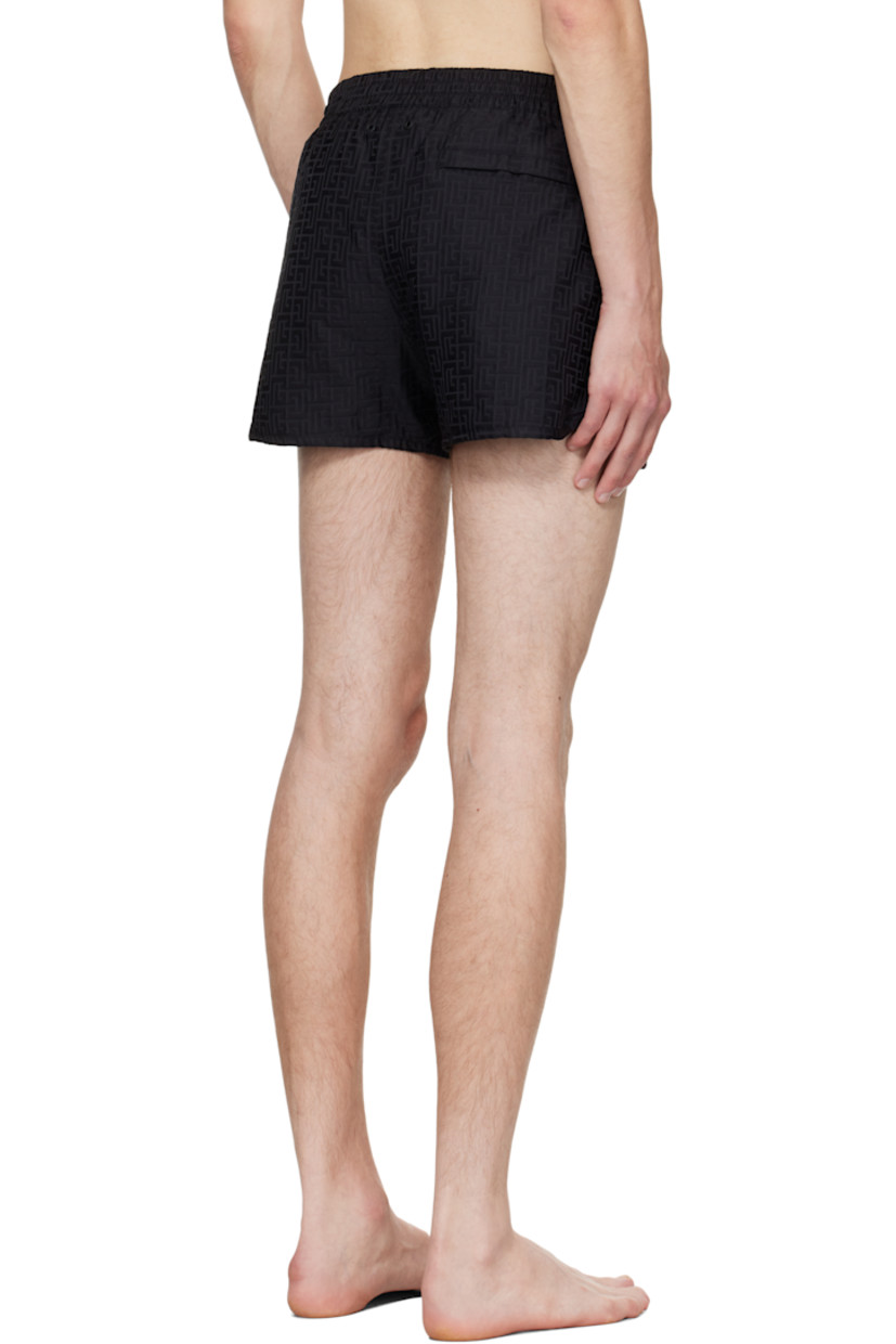 Twill swim shorts.

· Jacquard logo graphic pattern throughout 
· Drawstring at elasticized waistband 
· Three-pocket styling
· Grommets at back waist
· Mesh brief-style lining 

Supplier color: Black