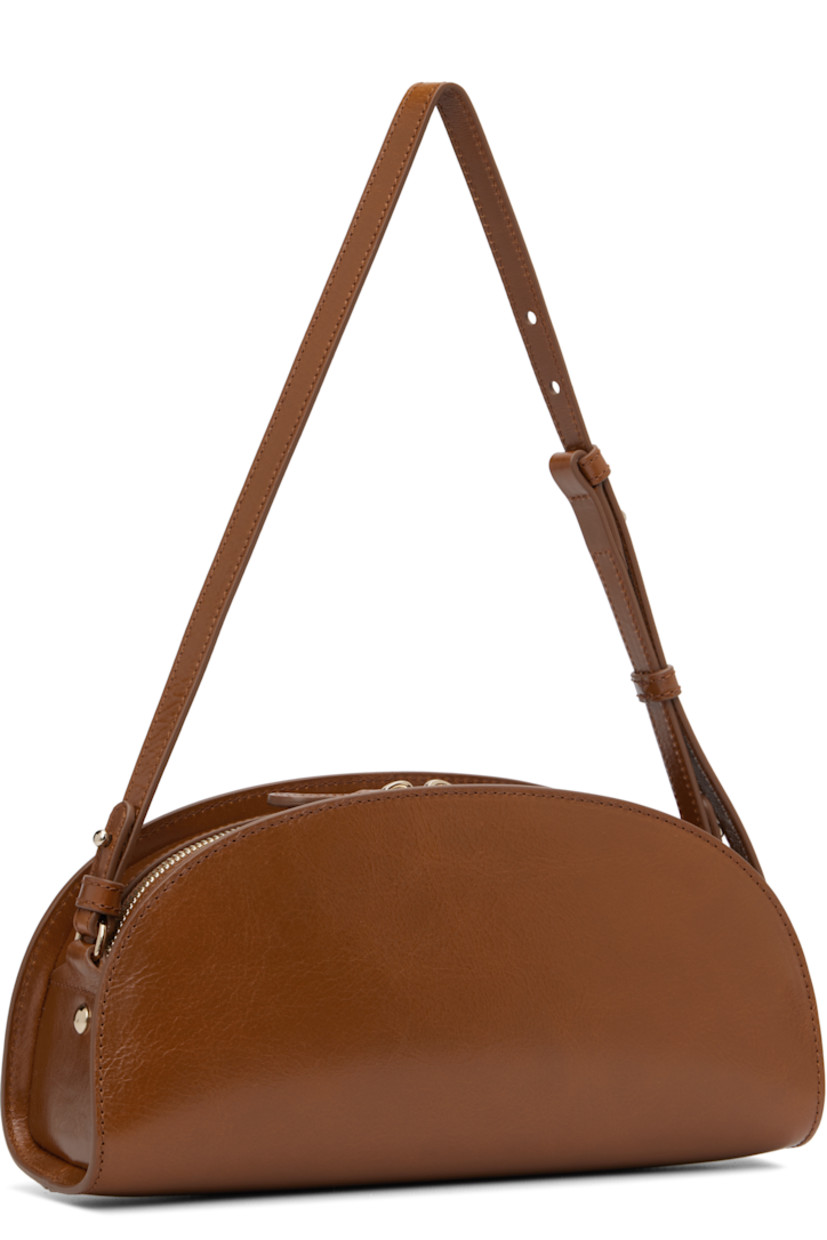 Crackled patent calfskin shoulder bag.

· Adjustable and detachable shoulder strap
· Gold-tone logo stamp at face
· Two-way zip closure
· Patch pocket at interior
· Cotton twill lining
· Gold-tone hardware
· H5.5" x W10.5" x D3.5"

Supplier color: Coffee