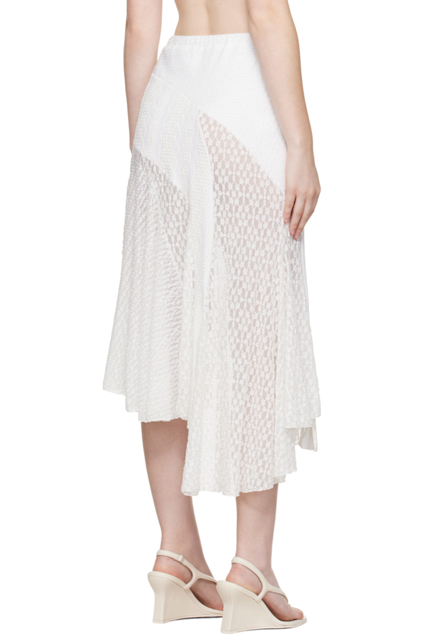 Semi-sheer stretch nylon cloqué and lace midi skirt. 

· Embroidered pattern throughout
· Paneled construction 
· Scalloped edge and satin bow at elasticized waistband
· Vents at asymmetric hem 

Supplier color: White