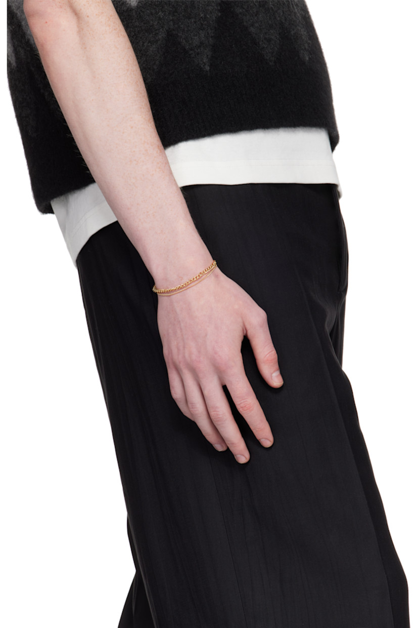 Tiered curb chain bracelet in gold-tone brass. Logo charm at lobster-clasp fastening.

Supplier color: Or