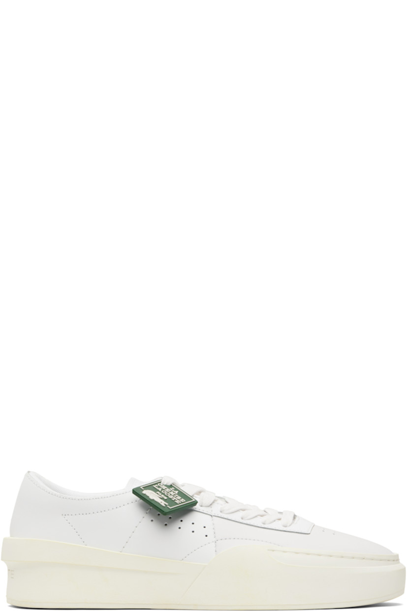 Low-top buffed leather sneakers.

· Perforations at toe and outer side
· Rubber logo tag at lace-up closure
· Woven tongue
· Padded collar
· Logo embossed at heel
· Mesh lining
· Treaded rubber sole
· Heel: H2"

Supplier color: White/Off white