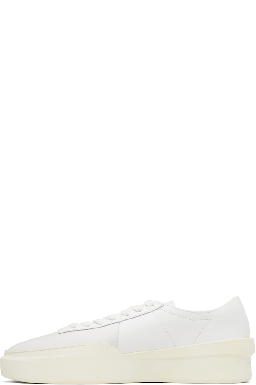 Low-top buffed leather sneakers.

· Perforations at toe and outer side
· Rubber logo tag at lace-up closure
· Woven tongue
· Padded collar
· Logo embossed at heel
· Mesh lining
· Treaded rubber sole
· Heel: H2"

Supplier color: White/Off white