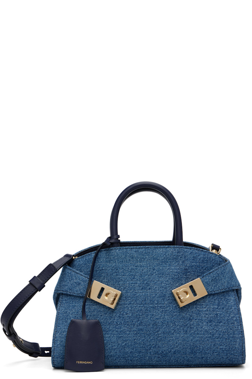 Denim top handle bag.

· Leather trim throughout
· Rolled carry handles
· Detachable sheathed keyring at handle
· Adjustable and detachable shoulder strap
· Flip-clasp strap at sides
· Patch pocket at interior
· H6” x W9” x D5”

Supplier color: Denim