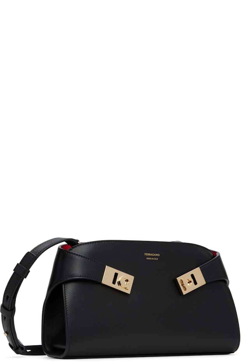 Vegetable-tanned buffed calfskin shoulder bag.

· Adjustable and detachable crossbody strap
· Flip-clasp straps and logo stamp at face
· Zip closure
· Card slots at interior
· Buffed leather lining
· Gold-tone hardware
· H5.5" x W9.25" x D2.5"

Supplier color: Black/Flame Red