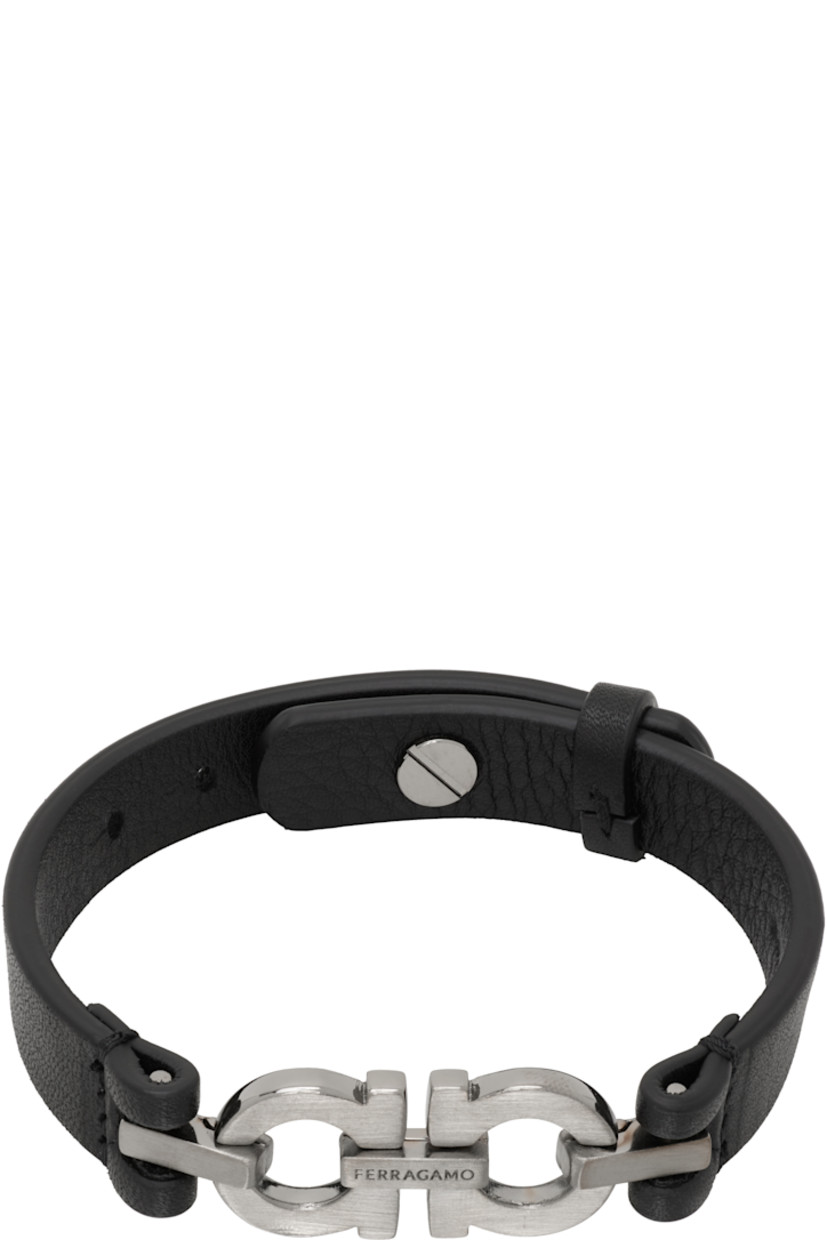 Buffed calfskin bracelet in black. 

· Logo hardware at face
· Keeper loop at length 
· Post-stud fastening 
· Brushed gunmetal-tone brass hardware
· L9.5"

Supplier color: Black