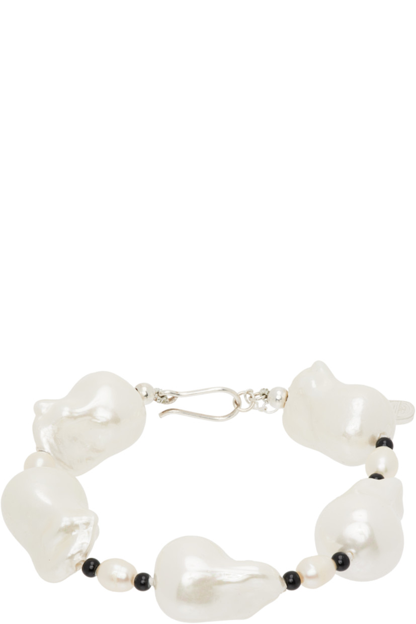 Beaded baroque pearl and onyx stone bracelet.

· Hand-knotted silk thread
· Logo plaque at adjustable hook fastening
· Sterling silver hardware
· L8"

Part of the Gohar World Table VII collection.

Supplier color: White/Onyx