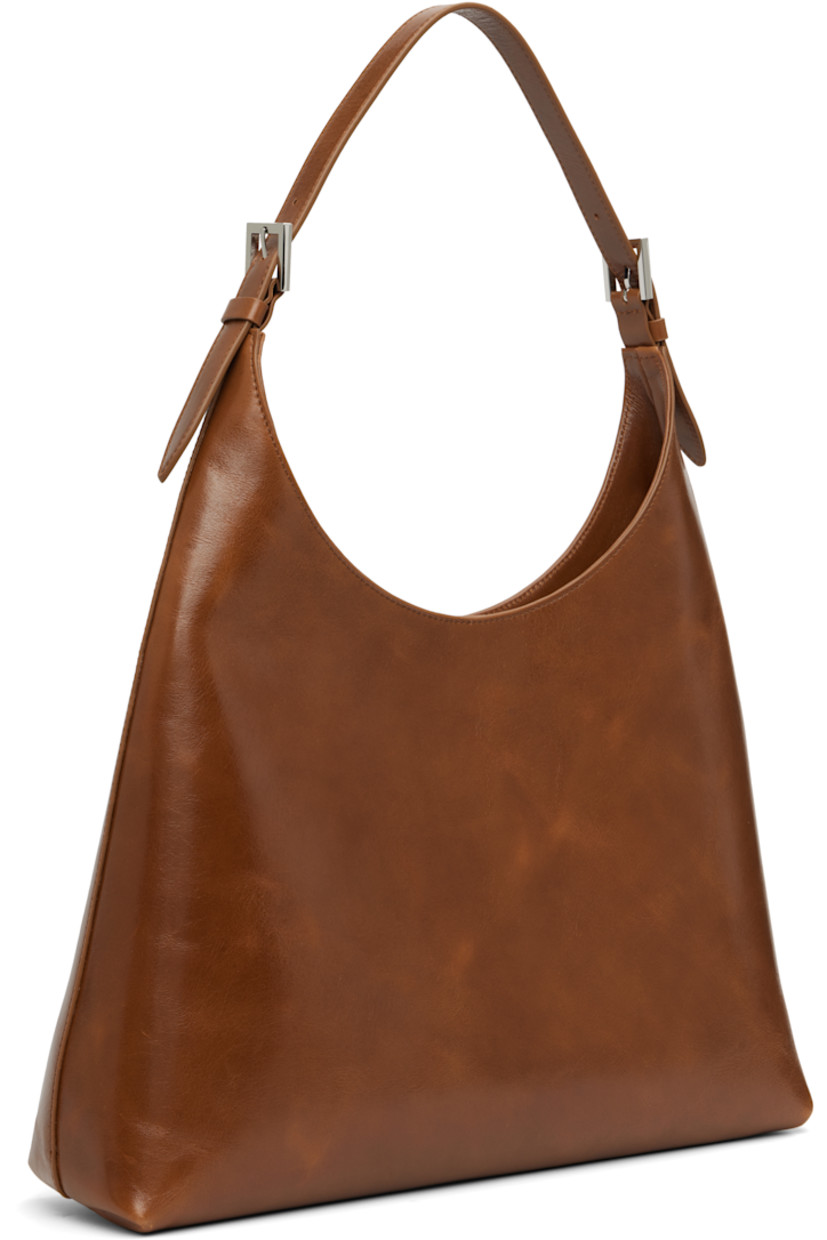 Crinkled leather shoulder bag.

· Adjustable and detachable shoulder strap
· Magnetic closure
· Patch pocket at interior
· Microfiber lining
· Logo-engraved silver-tone hardware
· H14" x W15" x D4"

Supplier color: Tan