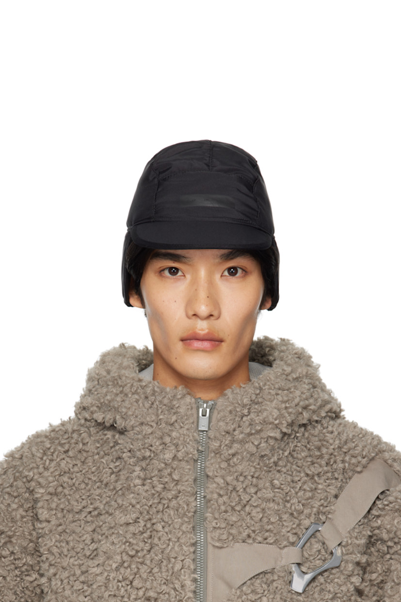 Reversible and padded taffeta cap. 

Reverse in black satin. 

· Flat brim 
· Stowaway ear flaps
· Cord-lock drawstring at back face 
· Logo-engraved silver-tone hardware 

Supplier color: Nylon black