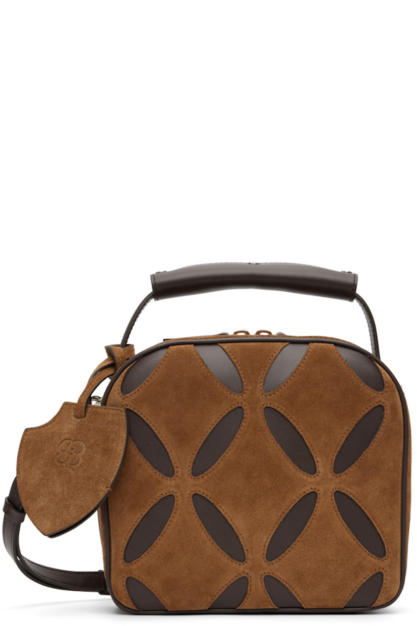 Suede and buffed leather top handle bag.

· Press-stud tab at carry handle
· Detachable sheathed keyring at handle
· Adjustable and detachable crossbody strap
· Graphic cutouts at face 
· Two-way zip closure
· Patch pocket at interior
· Twill lining
· H7.5" x W8.5" x D3.5"

Supplier color: Brown/Brown
