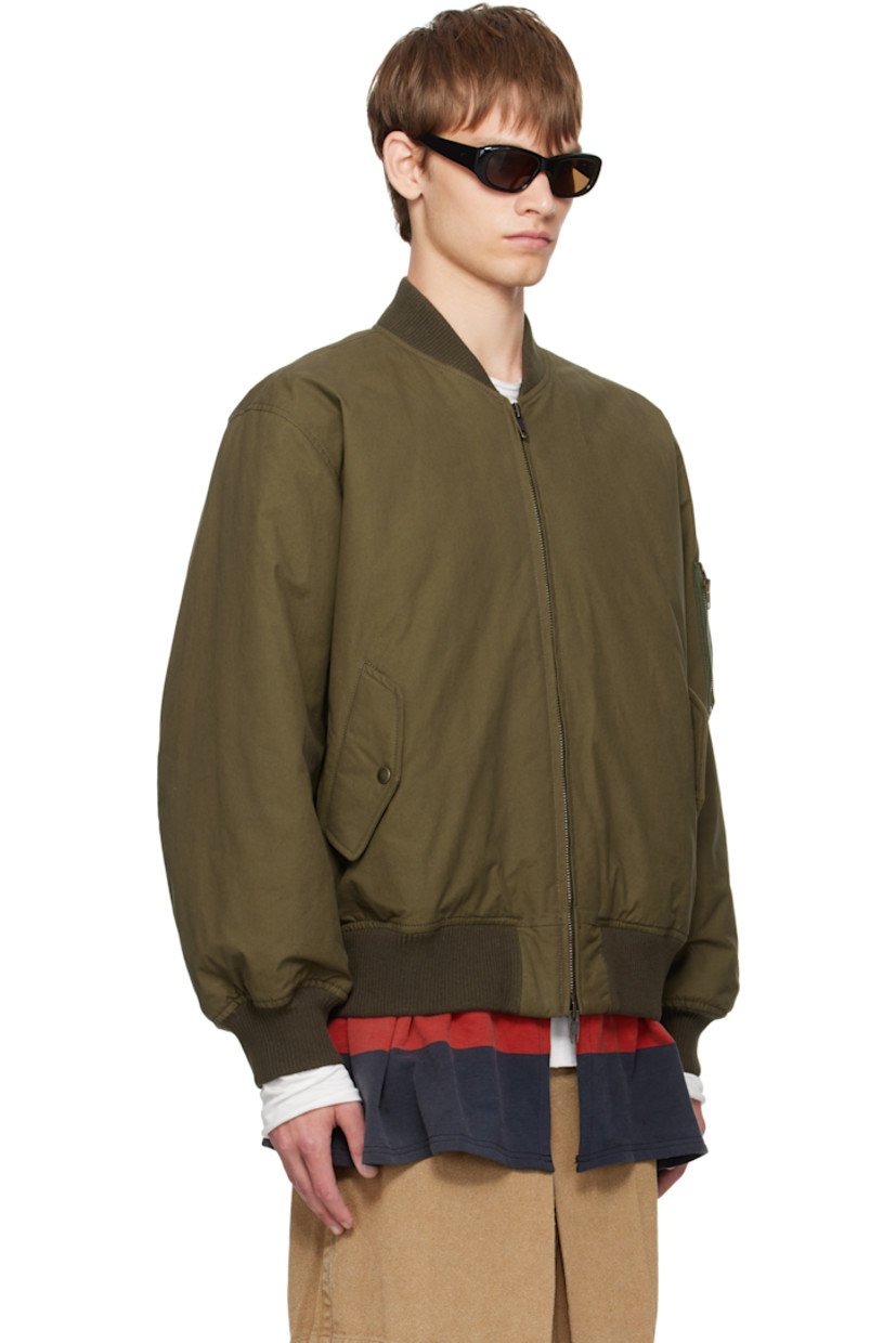 Padded cotton canvas bomber jacket. 

· Paneled construction
· Rib-knit stand collar, hem, and cuffs
· Two-way zip closure
· Flap pockets at waist 
· Striped jersey trim at hem 
· Utility pocket and pen slots at sleeve
· Welt pockets at interior 
· Full satin twill lining 

Each item is unique. Please note coloration and pattern may vary.

Supplier color: Green