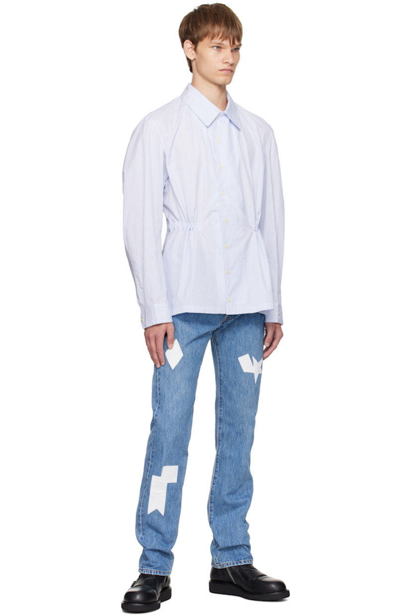 Cotton oxford cloth shirt. 

· Pinstripes throughout 
· Spread collar 
· Button closure
· Buttoned barrel cuffs
· Logo embroidered at cuff
· Self-tie drawstring at interior waist 

Supplier color: Blue pinstripe