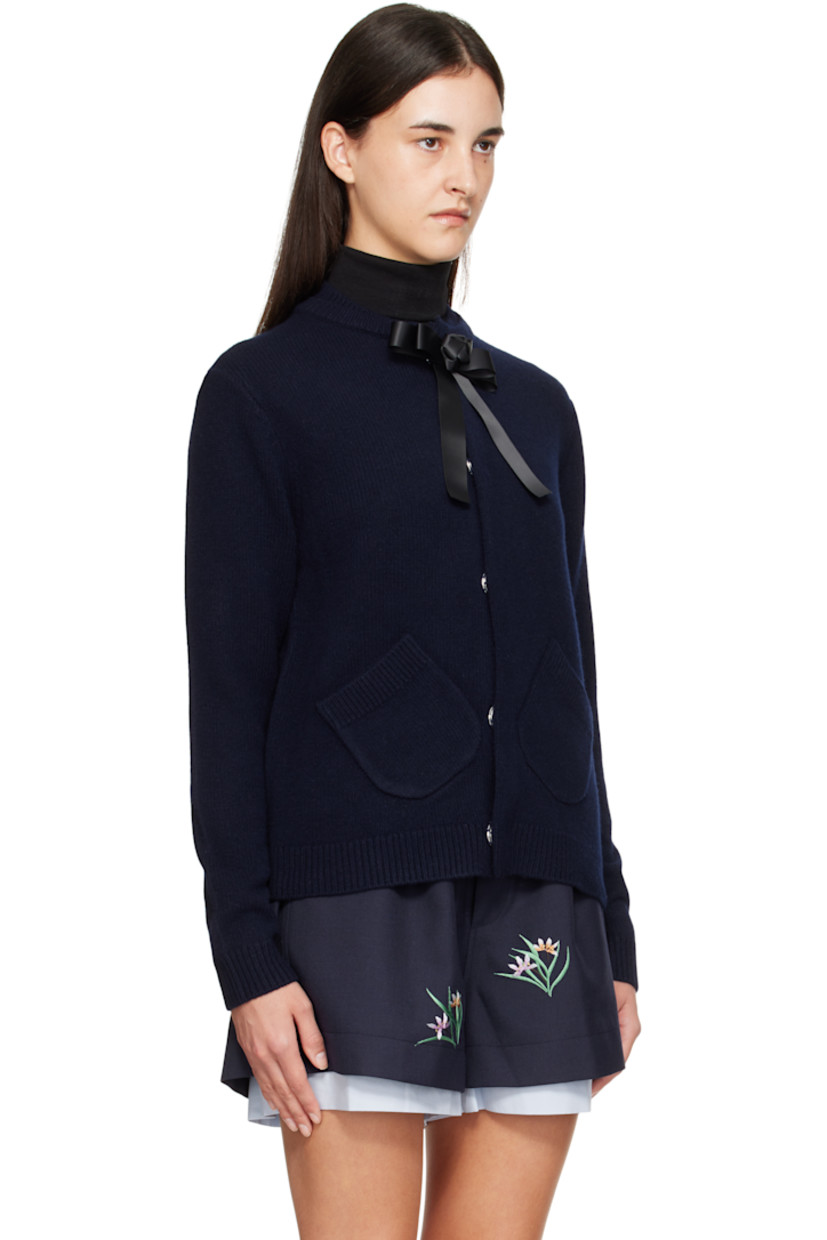 Brushed knit wool cardigan.

· Layered rib-knit round neck
· Concealed press-stud closure
· Detachable satin bow at top button
· Patch pockets at waist
· Rib-knit hem and cuffs
· Embroidered logo at back collar

Supplier color: Navy