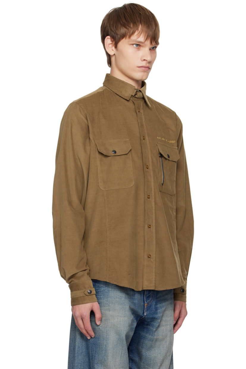 Organic cotton corduroy shirt.

· Cinch strap at spread collar and cuffs
· Button closure
· Logo embroidered at chest
· Flap pockets and zip pocket at chest
· Shirttail hem
· Press-stud barrel cuffs

Supplier color: Tobacco